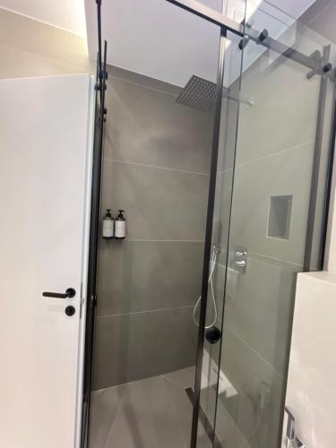 a shower with a glass door in a bathroom at Mina Luxury Rooms in Tirana