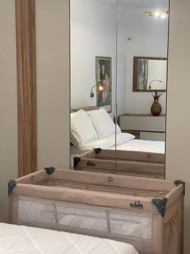 a reflection of a bedroom with two beds and a mirror at Appartamenti Trillionaire in Rivoli