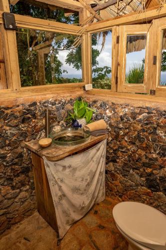 a bathroom with a sink and a stone wall at Casa El Paraiso, Eco Lodge in Santa Bárbara de Samaná
