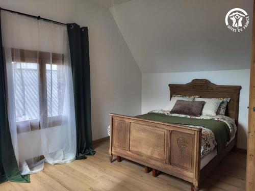 a bedroom with a bed and a wooden dresser at Chambre d'hôtes au coeur de la Ferme de la Porte en Aix pour 2 in Aix-en-Issart