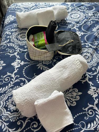 a basket of towels and a purse on a bed at The Old Brasserie & Rooms @ no.8 in Dartmouth