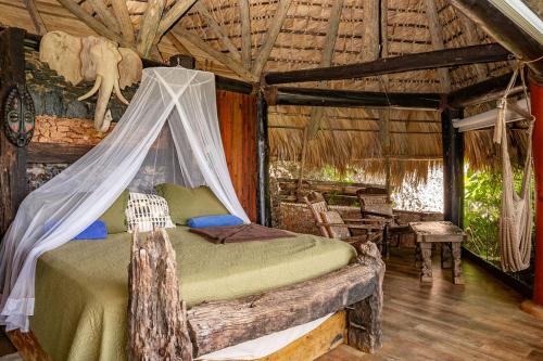 a bedroom with a bed in a log cabin at Casa El Paraiso, Eco Lodge in Santa Bárbara de Samaná