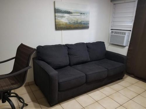 a black couch in a living room with a fan at Beach Apartment C3 Montones in Jobos