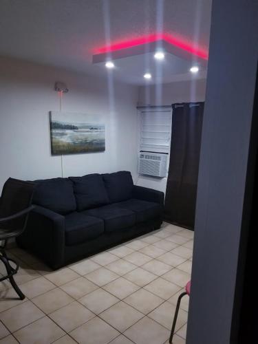 a living room with a black couch in a room at Beach Apartment C3 Montones in Jobos
