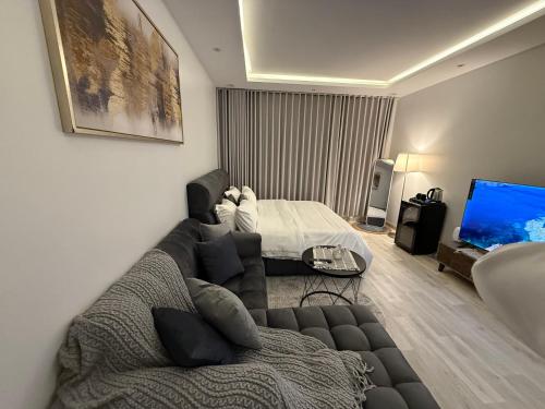 a living room with a couch and a bed at شقة تأجير يومي استوديو جديد بأثاث هادئ وأنيق in Riyadh