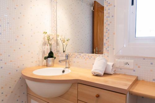 a bathroom with a sink and a mirror at AIGUAMARINA - Amor al mar y la vida in L'Ampolla