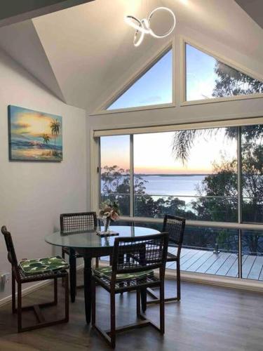 a dining room with a table and chairs and a large window at Lake View Oasis at Fishing Point in Fishing Point