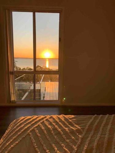 a bedroom with a window with a view of the ocean at Lake View Oasis at Fishing Point in Fishing Point