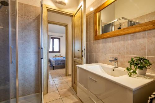 サン・テオドーロにあるMaison Apartments San Teodoro Centerの洗面台とシャワー付きのバスルーム
