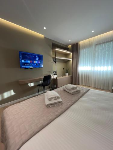a hotel room with a bed with two towels on it at Mina Luxury Rooms in Tirana