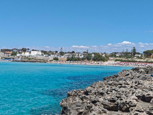 a view of a beach with blue water and rocks at la Casa di Giò in Pulsano