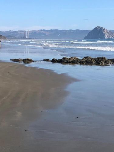 a beach with rocks in the sand and the ocean at Crafty Oak House in Paso Robles