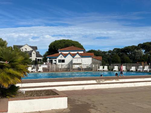 - une piscine avec 2 personnes dans l'eau dans l'établissement Coco studio 2 adultes et 2 enfants avec terrasse vue sur le Lac et accès parc aquatique gratuit, à Talmont-Saint-Hilaire