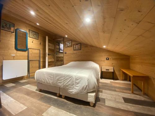 une chambre avec un lit dans une pièce en bois dans l'établissement Duplex rénové 6p au pied des pistes, expo sud, balcon et wifi à Morillon - FR-1-642-56, à Morillon