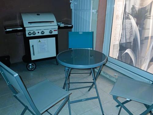 a glass table and two chairs and a stove at Superbe Villa 5 étoiles Presqu'Île de Giens la Madrague Rita la Villa d'Or vue mer piscine in Hyères