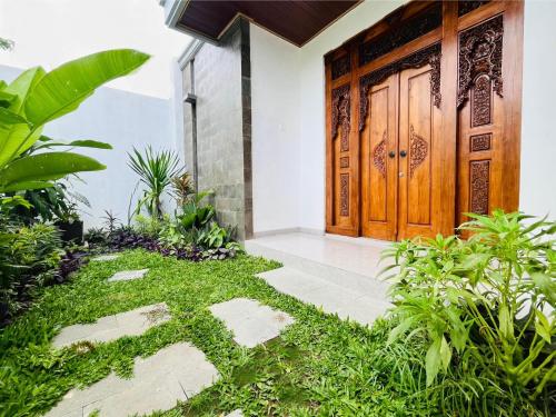 an entrance to a house with a wooden door at Deon house canggu in Tumbak Bayuh