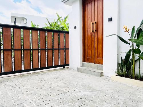 a house with a wooden door and a patio at Deon house canggu in Tumbak Bayuh