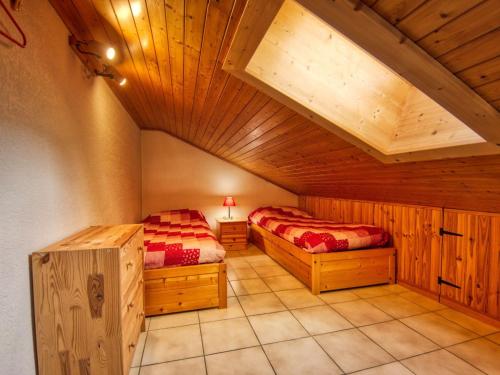 deux lits dans une chambre avec plafonds en bois dans l'établissement Duplex charmant au cœur de Morillon, près lac et navette, 5 pers, balcon, équipement complet - FR-1-642-99, à Morillon