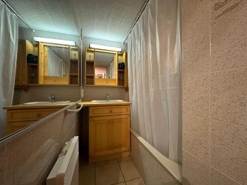 La salle de bains est pourvue de 2 lavabos et d'un rideau de douche. dans l'établissement Duplex charmant au cœur de Morillon, près lac et navette, 5 pers, balcon, équipement complet - FR-1-642-99, à Morillon