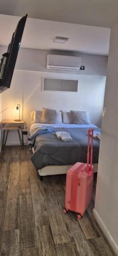 a bedroom with a bed and a suitcase at Departamento NYC 2 - Edificio VILAUT by INMOVE Temporarios in Córdoba