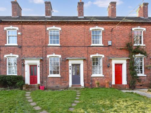 an old red brick house with red doors at Bliss House in Madeley