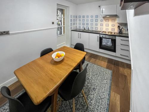 a kitchen with a wooden table and black chairs at Beach Oasis Cottage - Uk48530 in Margate