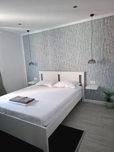 a bedroom with a large white bed with two lamps at Anatolí Apartment Sulina in Sulina