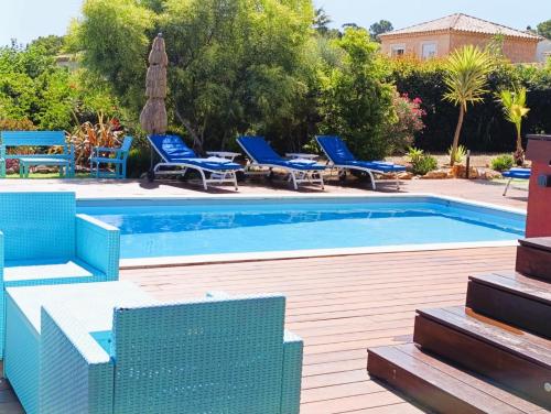 a swimming pool with blue lounge chairs and a swimming pool at Superbe Villa 5 étoiles Presqu'Île de Giens la Madrague Rita la Villa d'Or vue mer piscine in Hyères