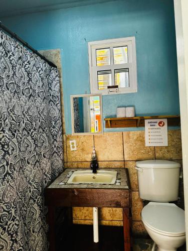 a bathroom with a toilet and a sink at Go Slow Guesthouse in Caye Caulker