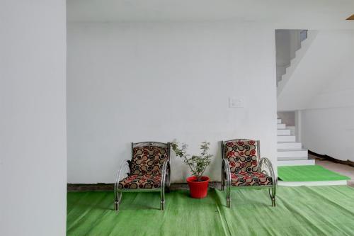 two chairs and a potted plant in a room at HOTEL O SPACE INN Nh 44 in Pānchgaon