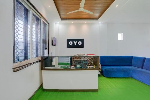 a living room with a blue couch and a aquarium at HOTEL O SPACE INN Nh 44 in Pānchgaon