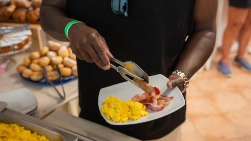 a person holding a plate of food with a spoon at Casa in Maremma Tuscany Village in Scarlino