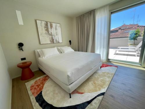a bedroom with a large bed and a large window at Opera Suite Hotel Pesaro in Pesaro