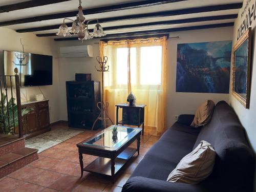 a living room with a couch and a glass table at Casa Rivendel - Fantasía, Confort y Naturaleza in Poyales del Hoyo