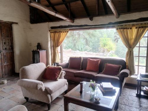 a living room with couches and a coffee table at Casa de campo Cucunuba cabaña Buena Vista in Cucunubá