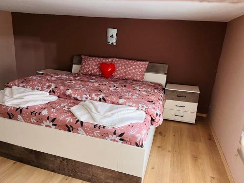 een slaapkamer met een bed met een rood hartkussen bij Апартамент за гости Николови in Vidin