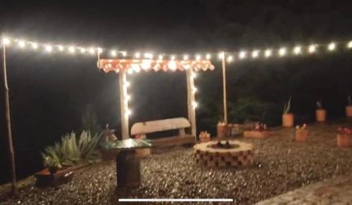a pergola with lights in a yard at night at Casa de campo Cucunuba cabaña Buena Vista in Cucunubá