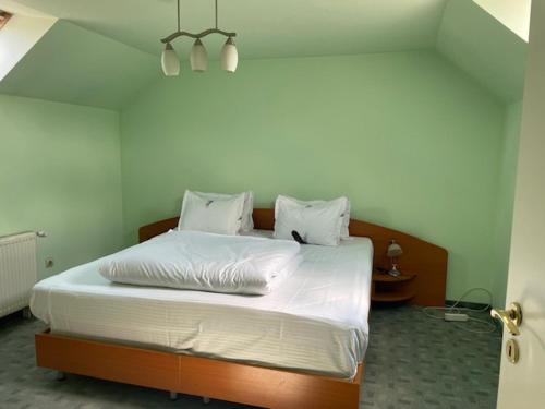 a bed with white sheets and pillows in a bedroom at Panorama Studio Sighisoara in Sighişoara