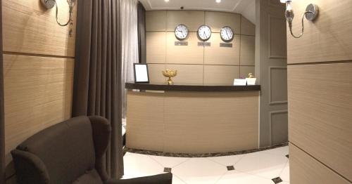 a hotel room with a reception desk and clocks on the wall at Orynbor Boutique Hotel in Astana