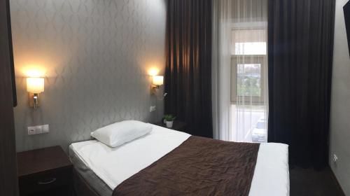 a hotel room with a bed and a window at Orynbor Boutique Hotel in Astana