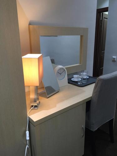 a desk with a lamp and a mirror on it at Orynbor Boutique Hotel in Astana
