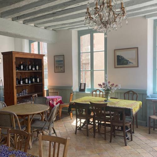 une salle à manger avec tables et chaises et un lustre dans l'établissement Aux lapins Bleus, à La Ferté-Vidame