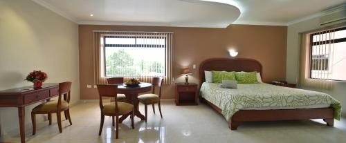1 dormitorio con cama, mesa y escritorio en Gran Hotel De Lago - El Coca, en Puerto Francisco de Orellana