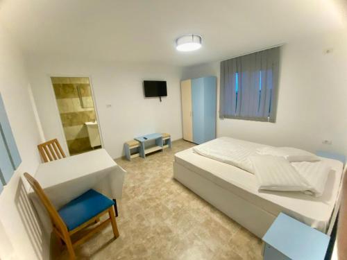 a bedroom with a bed and a chair and a tv at Pe Colț in Vama Veche