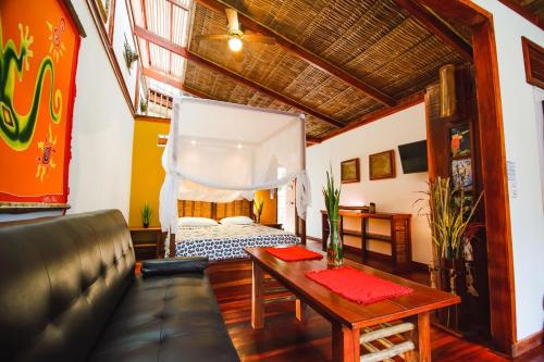 a living room with a bed and a table at Uva Blue Villas - Villa 2 - Modern 1 Bed Villa - Private Garden in Puerto Viejo