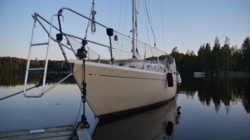 a boat is docked in a body of water at Accommodation on a sailboat in Sysmä harbour in Sysmä