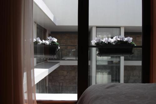 a bedroom with two flower pots on a window at Casas do Teatro in Porto