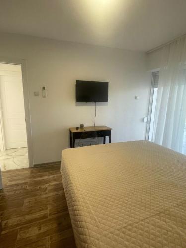 a bedroom with a bed and a television on a wall at Villa Mirijana in Zlatna Obala