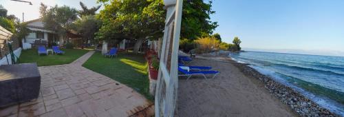 a view of a beach with chairs and the water at Agios Andreas Beach Villas in Áyios Andréas Messinias