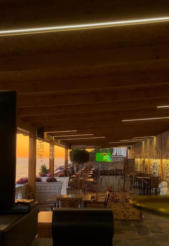 a restaurant with tables and chairs and a view of the ocean at Luxury Villa Alisja Sarande with Private Beach in Sarandë